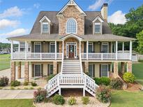 Stunning home featuring a stone facade and inviting wraparound porch, offering a blend of elegance and charm at 92 River Walk Pkwy, Euharlee, GA 30145