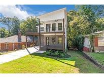 Striking two-story home with a modern design, balconies, well-kept lawn, and lush, mature trees around the property at 1464 Ezra Church Nw Dr, Atlanta, GA 30314
