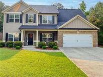 Charming two-story home featuring a manicured lawn, brick accents, and a welcoming front porch at 4560 Buckskin Way, Douglasville, GA 30135