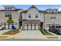 Charming townhome featuring a two-car garage, brick accents, and well-maintained landscaping at 94 Depot Landing Rd, Auburn, GA 30011
