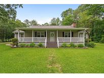 Charming single-story home featuring a welcoming front porch and a well-maintained lawn at 1267 Austin Bridge Rd, Douglasville, GA 30134