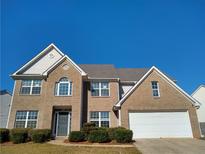 Charming brick two-story home with attached two-car garage and manicured landscaping at 838 Roxholly Ln, Buford, GA 30518