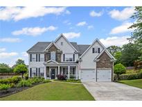 Traditional two-story home with stone accents, attached two car garage, well-manicured lawn, and inviting curb appeal at 121 Bradshaw Park Dr, Woodstock, GA 30188