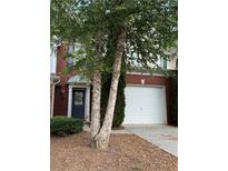 Charming brick front exterior with a two-car garage and a beautiful tree in the front yard at 2008 Hailston Dr, Duluth, GA 30097