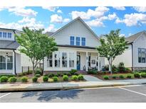 Charming two-story home featuring a welcoming front porch and manicured landscaping at 1002 Harvest Park Ln, Suwanee, GA 30024