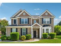 Charming two-story home with a brick and siding exterior, manicured landscaping, and a welcoming front porch at 3134 Flery Way, Lawrenceville, GA 30046