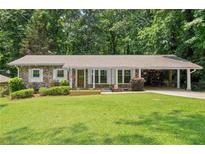 Charming brick home with well-manicured lawn and covered parking at 4371 N Park Dr, Tucker, GA 30084