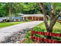 Charming home featuring a long driveway and inviting curb appeal with mature trees and red shutters at 5152 Suggs St, Powder Springs, GA 30127