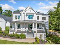 Charming two-story home with a welcoming front porch and professionally landscaped yard at 200 Whispering Pines Dr, Woodstock, GA 30188