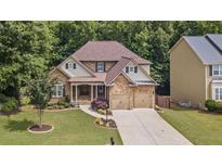 Beautiful stone and siding home with a two-car garage and well-manicured lawn at 2430 Hemrick Rd, Cumming, GA 30041