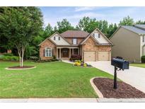 Charming two-story home featuring a stone facade, well-manicured lawn, and a two-car garage at 2430 Hemrick Rd, Cumming, GA 30041