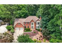 Elegant brick home nestled among trees with a well manicured lawn and a two car garage at 3741 Bays Ferry Way, Marietta, GA 30062