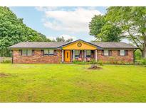 Charming brick home with a bright, welcoming front door and a well-manicured lawn at 2696 Eldorado Pl, Snellville, GA 30078
