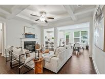 Bright living room features a fireplace, modern furniture, and open access to the kitchen and dining area at 2235 Mulsanne Dr, Lithonia, GA 30058