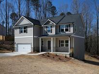 Charming two-story home features a covered porch, attached garage, and neutral siding, creating an inviting curb appeal at 250 Shawnee Trl, Dallas, GA 30157