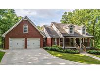 Charming brick home with a two-car garage, landscaped yard and inviting front porch at 180 Mountain Path, Rockmart, GA 30153