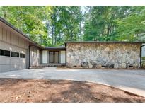 Ranch-style home with stone exterior and a two-car garage at 235 Trailmore Ct, Roswell, GA 30076