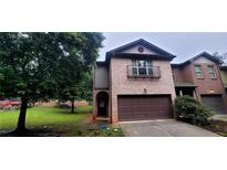 Charming two-story brick home with a covered entry, two car garage, and landscaped front yard at 5719 Singlebriar Ct, Norcross, GA 30093