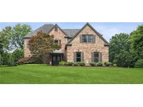 Elegant brick home with a well-manicured lawn and mature landscaping offers classic curb appeal at 1800 Hunters Moon Dr, Alpharetta, GA 30005