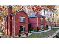 Charming brick home featuring manicured landscaping, a fenced yard, and mature trees at 271 Brooks Rackley Rd, Dallas, GA 30157