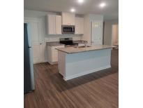 Bright kitchen features stainless steel appliances, granite countertops and a center island at 558 Fairview Oak Pl, Dallas, GA 30157