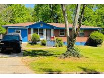 Charming single-story brick home with a blue trim, complemented by a well-maintained front yard at 1934 Apache Se Trl, Atlanta, GA 30316