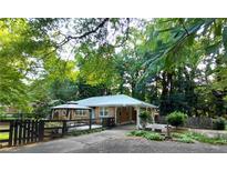 Charming brick home featuring a covered entrance, gazebo, and mature trees creating a serene, shaded front yard at 2225 Harold Se Ln, Smyrna, GA 30080