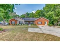 Charming single-story home featuring a brick facade, well-maintained lawn, and a concrete driveway at 3706 Bouldercrest Rd, Ellenwood, GA 30294