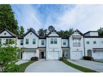 Charming townhomes featuring white exteriors, driveways, and well-maintained landscaping at 4175 Spring Valley Cir, Tucker, GA 30084