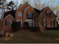 Charming two-story brick home with black shutters, landscaped yard, and mature trees in a desirable neighborhood at 7071 Glen Cove Ln, Stone Mountain, GA 30087