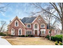 Charming two-story brick home with landscaped yard, gabled roof, and an inviting entrance at 2760 Sugarloaf Club Dr, Duluth, GA 30097