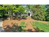Charming home featuring a well-manicured lawn with mature trees and inviting front porch at 3875 Sweetwater Dr, Cumming, GA 30041