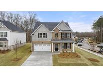 Beautiful two-story home with brick and siding exterior, well-manicured lawn, and attached two-car garage at 13574 Se Whitman Ln, Covington, GA 30014
