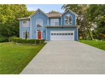 Charming two-story home with blue siding, an attached garage, and a well-manicured front lawn at 1901 Cherwell Dr, Riverdale, GA 30296