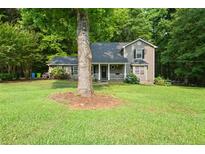 Charming two-story home features a welcoming front porch and well-maintained lawn at 135 Dunwick Ln, Mcdonough, GA 30253