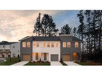Charming townhome featuring a mix of siding colors, a driveway and an attached garage at 1670 Gunnin Nw Trce # 256, Atlanta, GA 30318