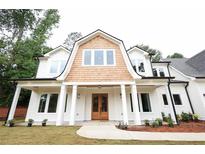 A charming home featuring a light-colored exterior, wood accents, and a welcoming front porch at 219 Poplar Nw St, Lilburn, GA 30047