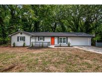 Charming, newly renovated single-story home featuring a bright orange front door and modern exterior paint at 5640 Redan Cir, Stone Mountain, GA 30088