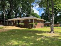 Charming brick home with a well-maintained front yard and mature trees at 4925 Sugar Valley Sw Rd, Mableton, GA 30126