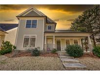 Charming two-story home featuring a welcoming front porch, beautiful landscaping, and a well-maintained front yard at 5114 Arnold St, Covington, GA 30014