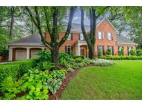 Stately brick home featuring a well manicured lawn and flower beds, creating a welcoming curb appeal at 663 Clifton Ne Rd, Atlanta, GA 30307