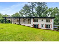 Charming home with a covered porch and well-manicured lawn, surrounded by mature trees at 3536 Redwine Ct, Atlanta, GA 30344