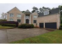 Elegant brick home with a two-car garage, landscaped front yard, and a beautiful entryway at 168 Harmony Grove Rd, Lilburn, GA 30047