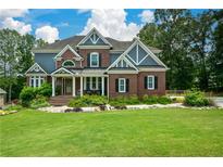 Stunning two-story brick home with a manicured lawn and inviting front porch with stately columns at 2637 Morningside Nw Trl, Kennesaw, GA 30144