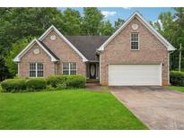 Charming brick home with a well-manicured lawn and a two-car garage at 605 Pebble Blvd, Covington, GA 30016