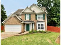 Charming two-story brick home with green shutters, lush lawn, and a two-car garage at 4424 High Gate Nw Dr, Acworth, GA 30101