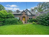 Charming brick Tudor-style home featuring a well-manicured lawn and lush greenery in a desirable neighborhood at 451 S Columbia Dr, Decatur, GA 30030