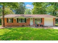 Charming brick ranch-style home featuring a well-manicured lawn and an attached one car garage at 57 Jonathan Rd, Riverdale, GA 30274