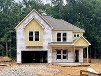 New construction home featuring a two-story design, attached garage, and situated on a wooded lot at 731 Crest Line Trl, Powder Springs, GA 30127