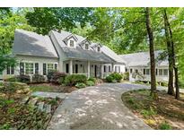 Charming white home featuring black shutters, dormer windows, covered porch and a paved driveway at 2058 Sewanee Ct, Villa Rica, GA 30180